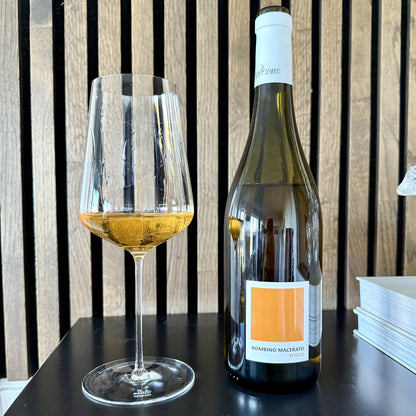 Wine bottle and glass with white wine on a wooden background