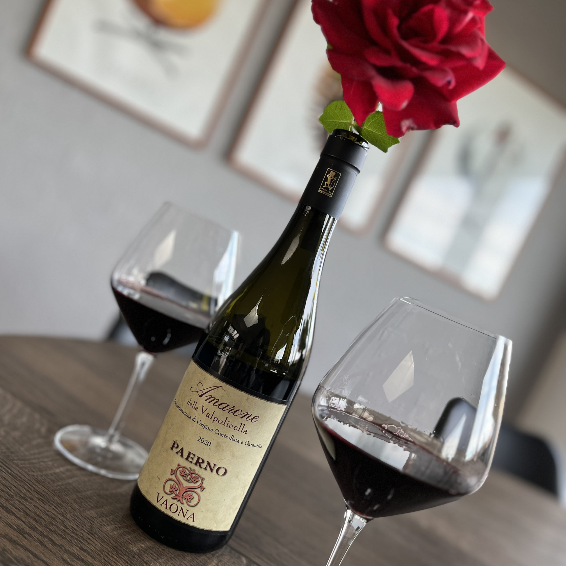 An alternative angle of the wooden table arrangement, showcasing the red wine glasses and opener, with the red rose now resting directly on the neck of the Vaona Amarone wine bottle.